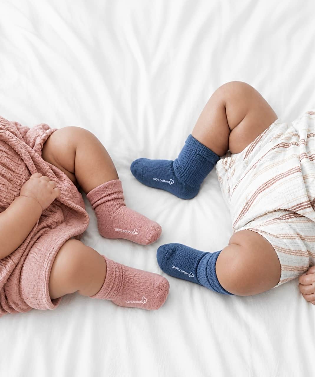 Two babies wearing ribbed cotton baby socks in blue and pink, soft breathable everyday baby socks for infants