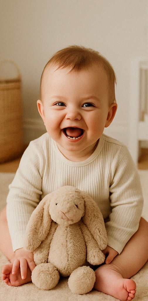 Close-up of a baby exploring a wooden teether and soft fabric book, representing sensory play and natural design values.
