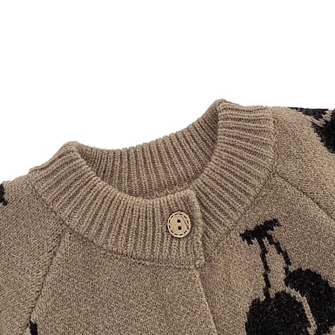 Close-up of round neck detail on baby cherry knit romper showing soft ribbed collar.
