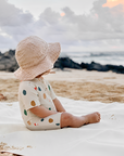 Toddler wearing abstract print zip swim romper sitting on beach, lightweight stretchy baby summer swimsuit for outdoor play