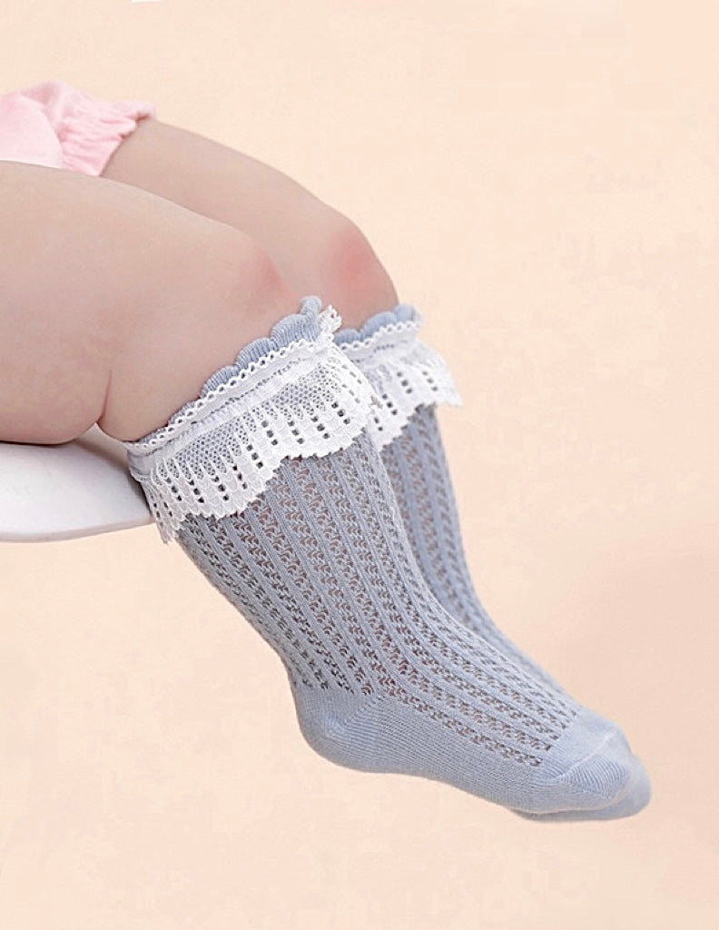 Adorable baby wearing blue lace mesh cotton socks, breathable summer socks for toddlers and girls.