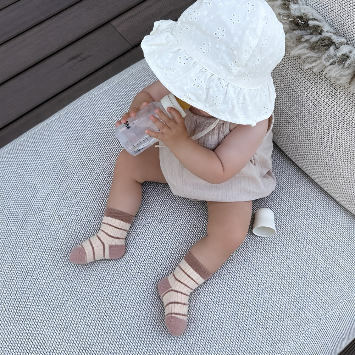 Baby wearing brown striped thick winter cotton socks for babies and toddlers indoors