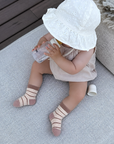 Baby wearing brown striped thick winter cotton socks for babies and toddlers indoors