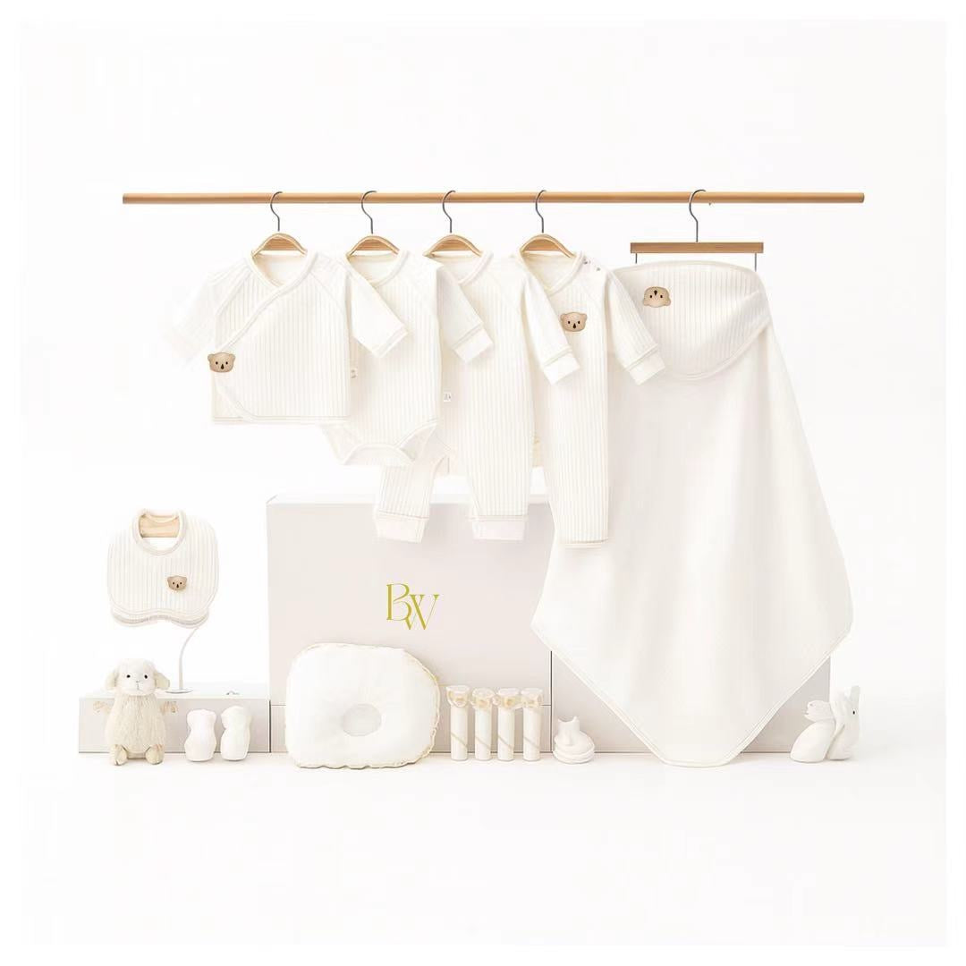 Luxury baby clothing gift set with newborn essentials including onesies, blanket, bib, and plush toy
