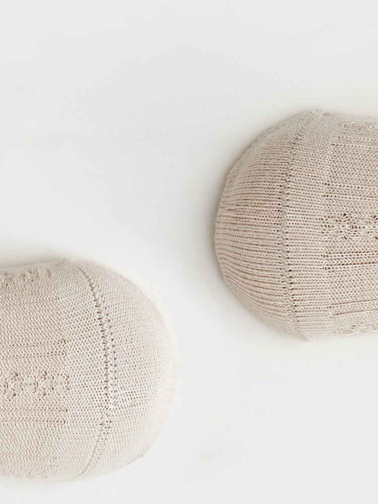 Soft beige baby cotton socks close-up showing fine knit texture and breathable fabric.