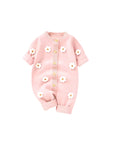 Pink knitted baby romper with 3D white daisy flowers and wooden buttons on the front