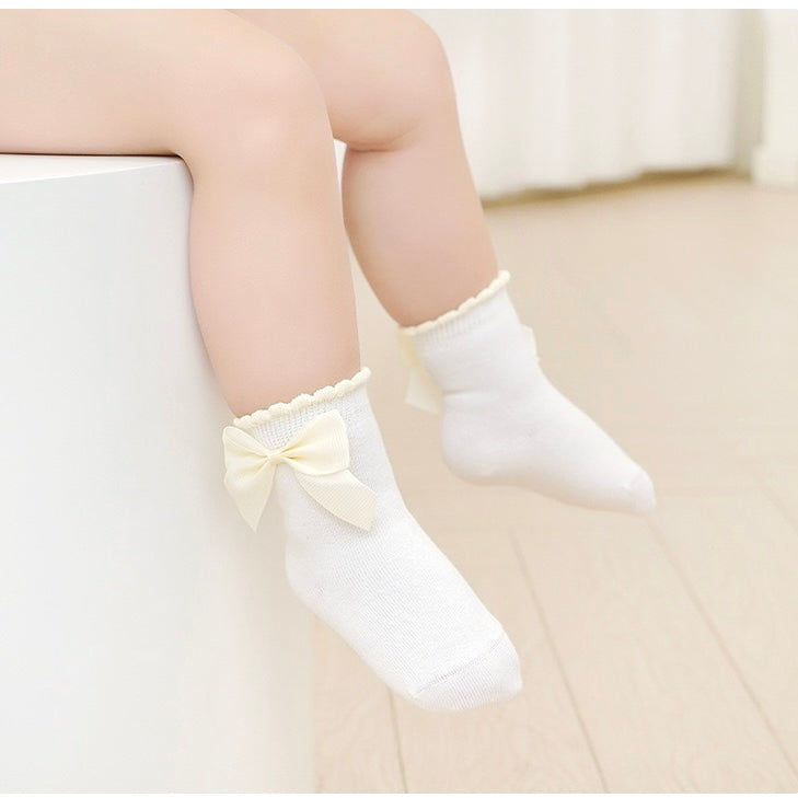 Baby girl wearing bow baby socks – cream cotton socks with satin ribbon detail UK