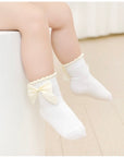 Baby girl wearing bow baby socks – cream cotton socks with satin ribbon detail UK