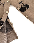 Detailed view of button design and inside stitching on baby cherry knit romper.
