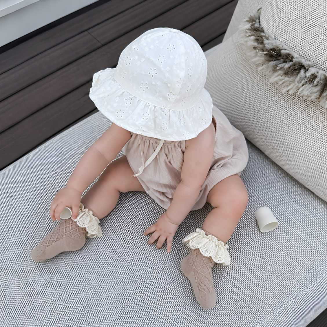 Baby wearing neutral lace frill cotton socks with soft ruffle trim and bow detail