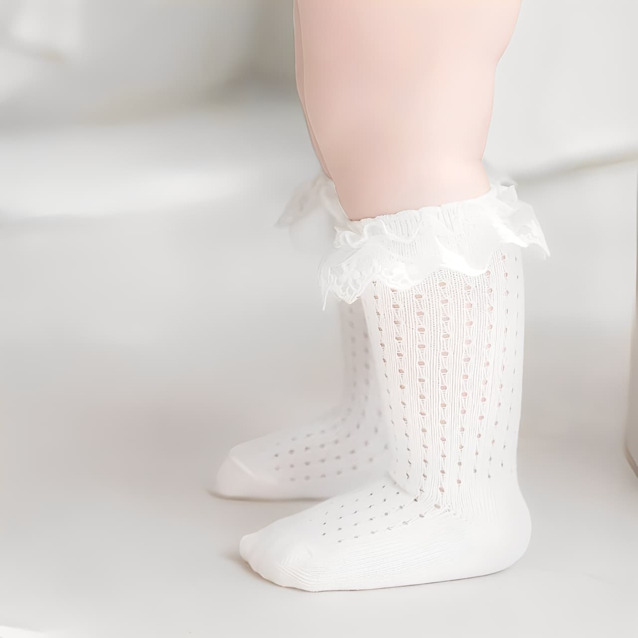 Baby wearing white lace knee-high cotton socks, breathable and soft toddler ruffle socks
