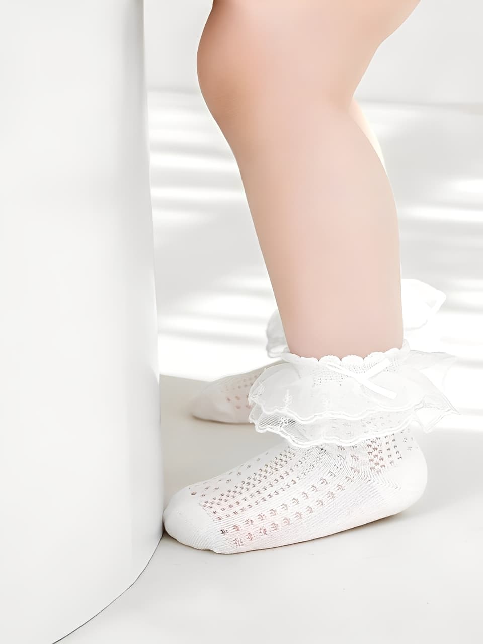 Baby wearing lace ruffle socks made of soft breathable cotton with frilled cuffs for comfort and style