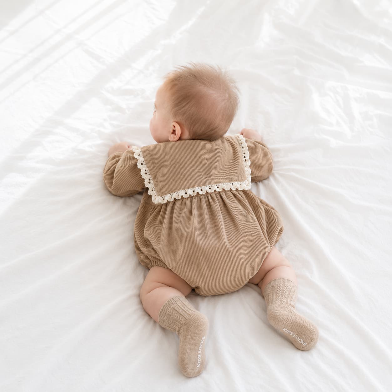 Baby wearing brown lace collar romper with cable knit anti-slip baby socks