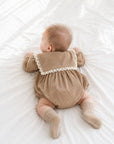Baby wearing brown lace collar romper with cable knit anti-slip baby socks
