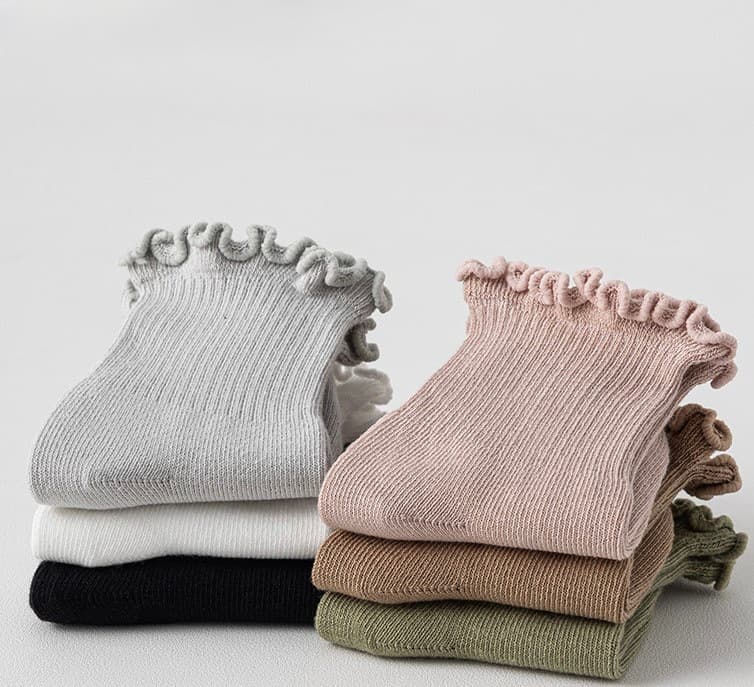 Set of six folded baby ruffle socks in neutral cotton colors, soft and breathable