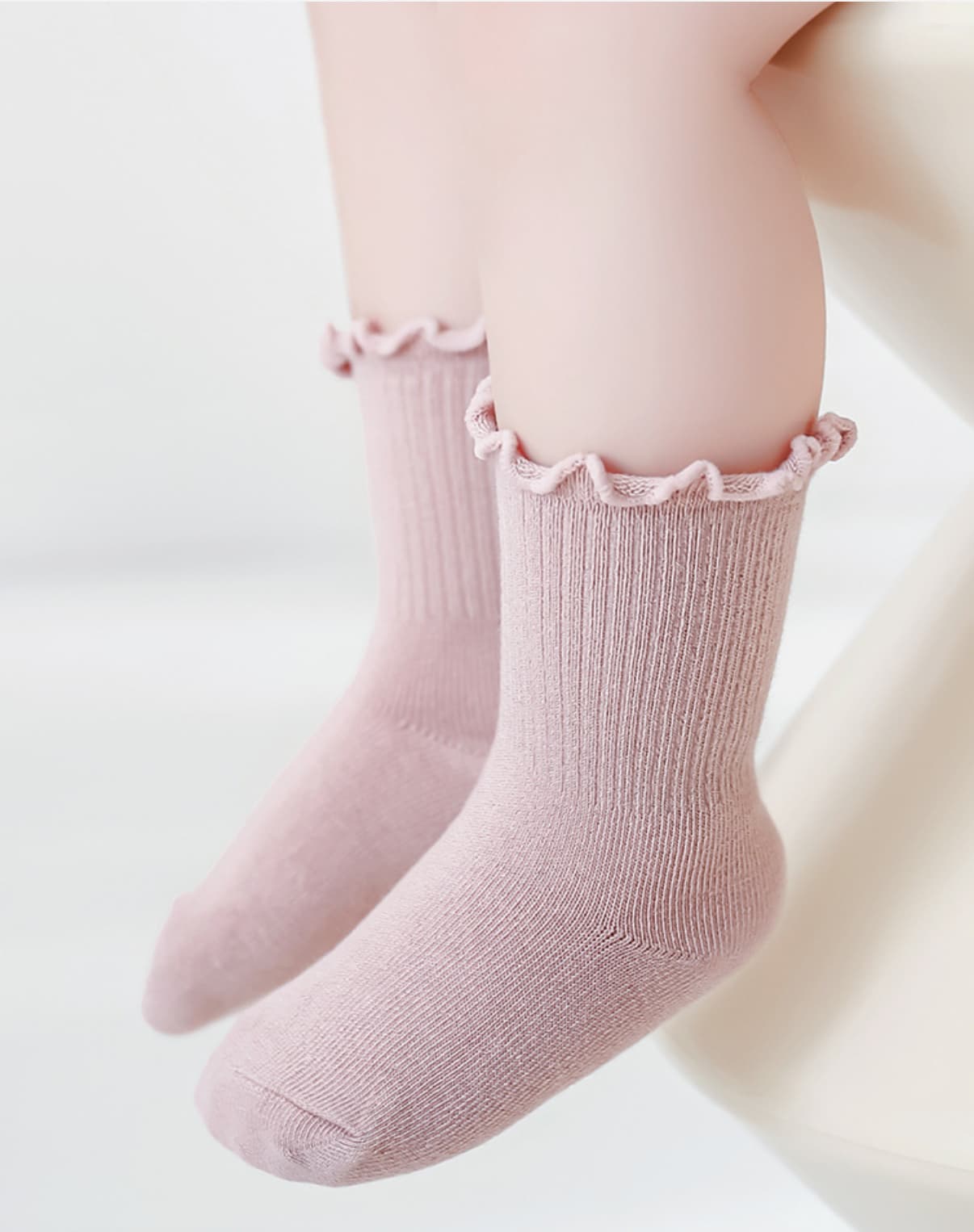Pink cotton baby socks with frilled cuff, worn by baby for soft daily comfort