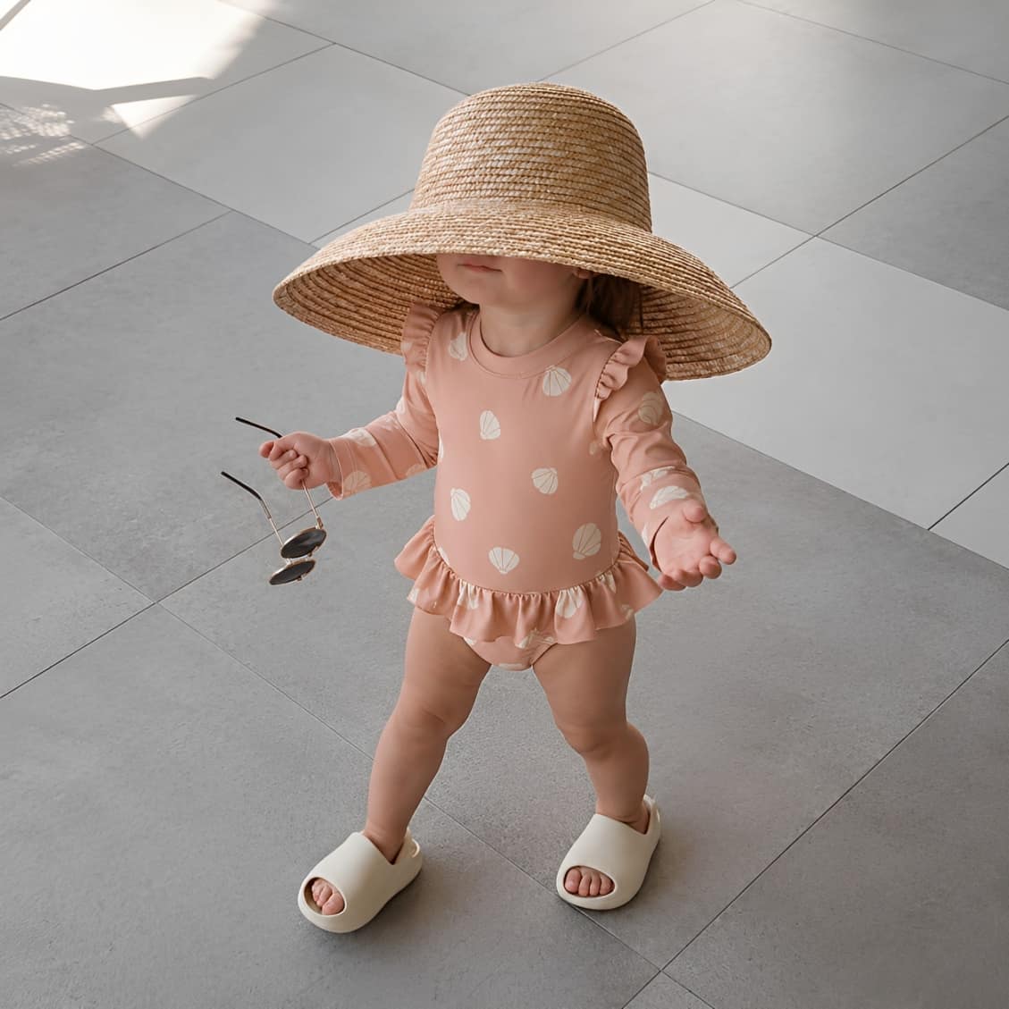 baby pink long sleeve swimsuit with shell print and ruffle details
