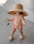 baby pink long sleeve swimsuit with shell print and ruffle details
