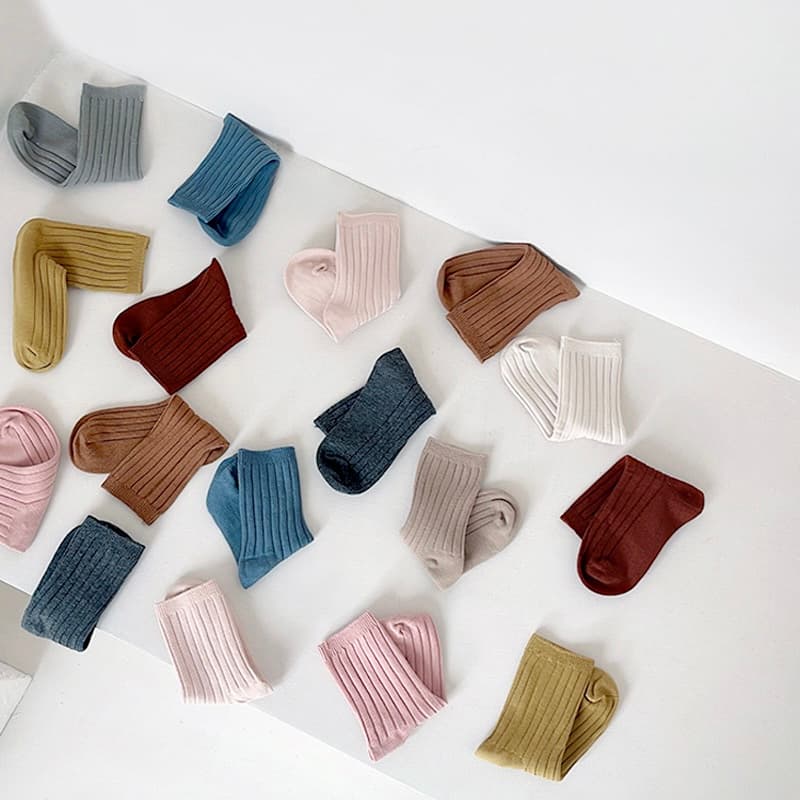 Baby and toddler ribbed socks in assorted neutral and pastel colors displayed flat on white background
