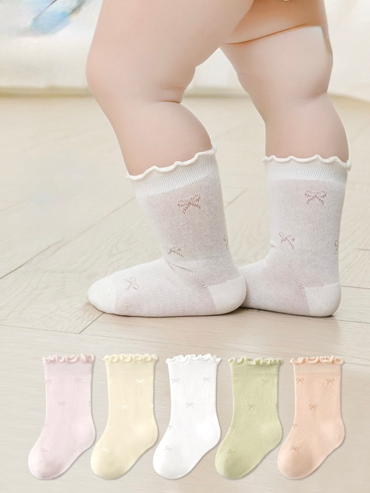 Baby wearing cream lace-trim cotton baby socks – frilled edge socks UK