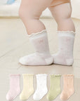 Baby wearing cream lace-trim cotton baby socks – frilled edge socks UK