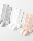 Baby wearing white knee-high bow socks – cozy and classic cotton knit BabyWonders UK
