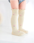 Baby wearing pastel yellow scalloped knee-high socks – soft cotton baby socks UK