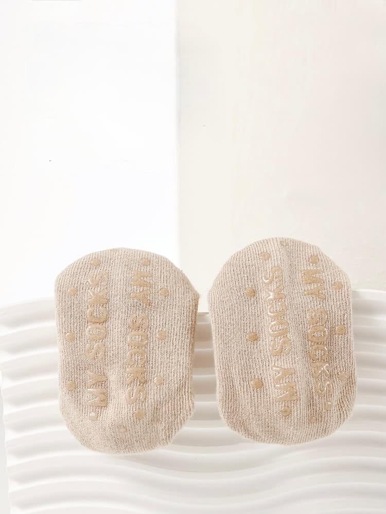 Close-up of beige baby socks with anti-slip sole and soft cotton texture