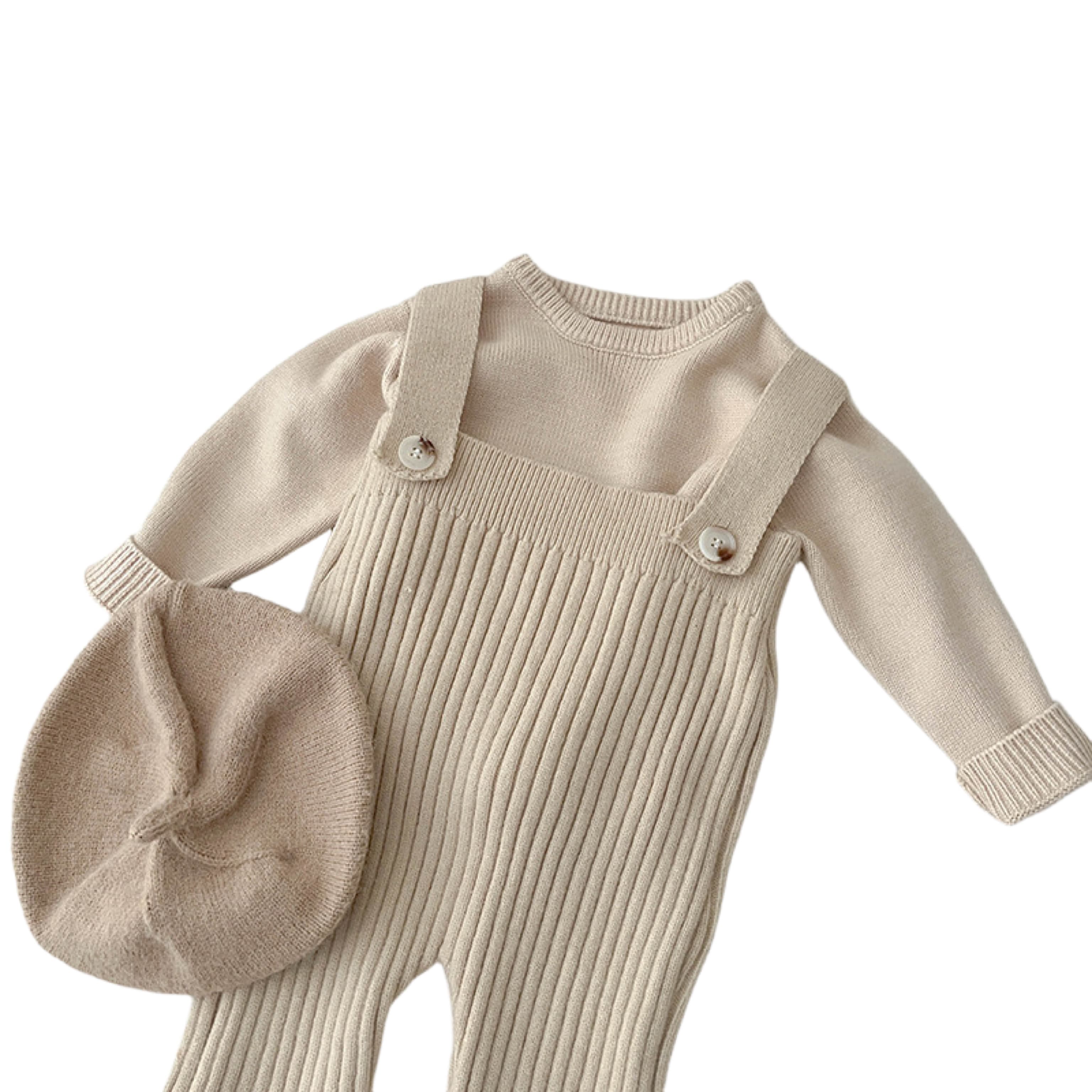 Close-up of beige baby knitted overall outfit with ribbed texture and matching beret hat