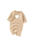 Beige knitted baby jumpsuit with white heart pattern and cozy texture for fall and winter wear
