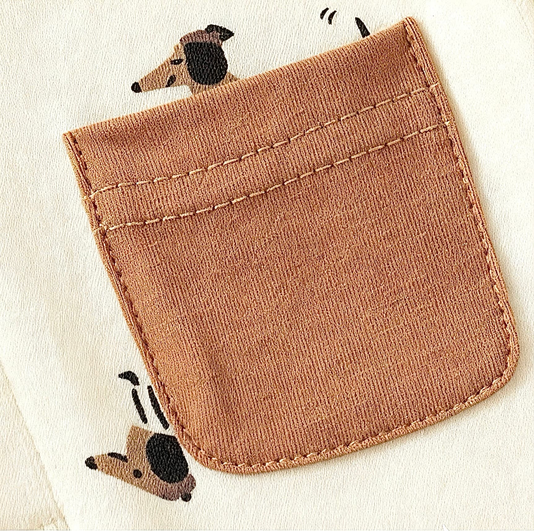 Brown pocket detail with cute puppy print on beige cotton baby romper.
