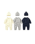 Cable knit baby rompers in ivory, gray, and navy blue with matching hats, perfect for winter comfort.
