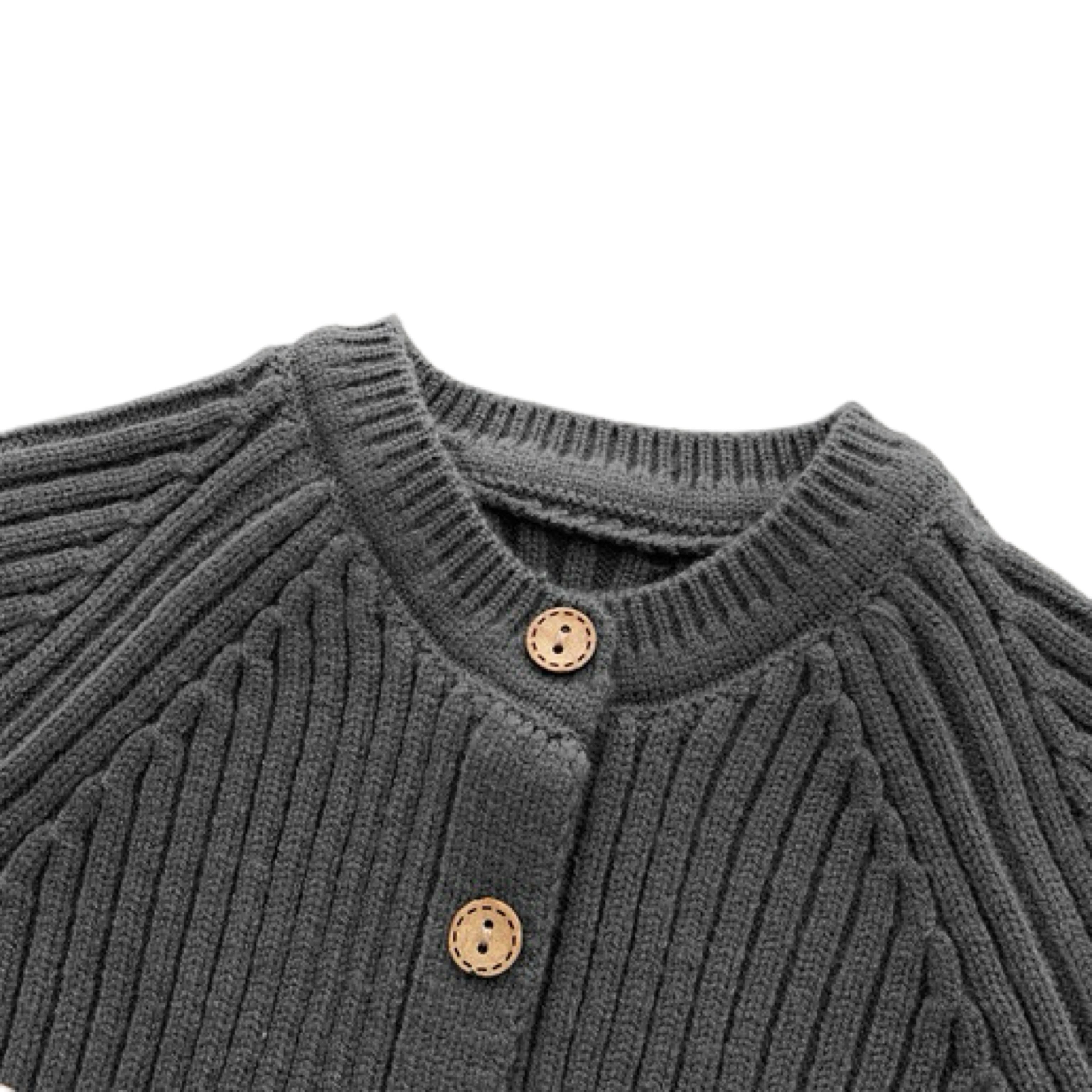 Close-up of charcoal knit baby romper neckline with wooden buttons and ribbed texture
