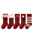 Five pairs of Christmas red baby socks with lace, bow, pom pom, and striped designs made from soft cotton.
