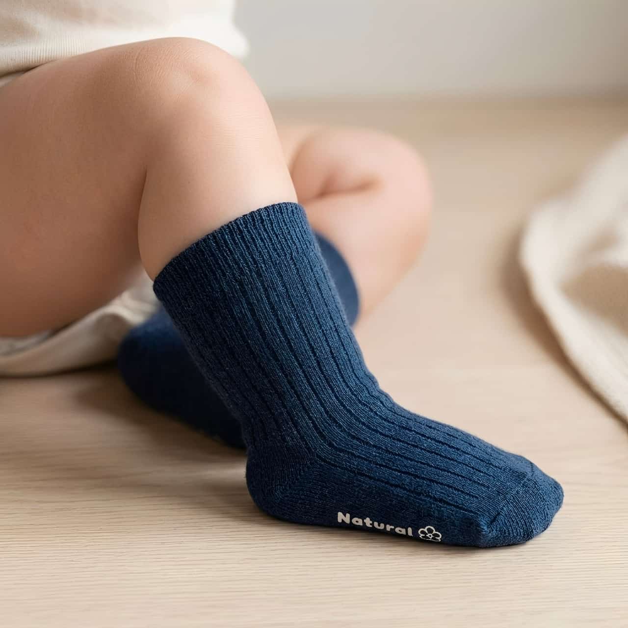 Baby wearing navy cotton socks on feet, soft breathable fabric
