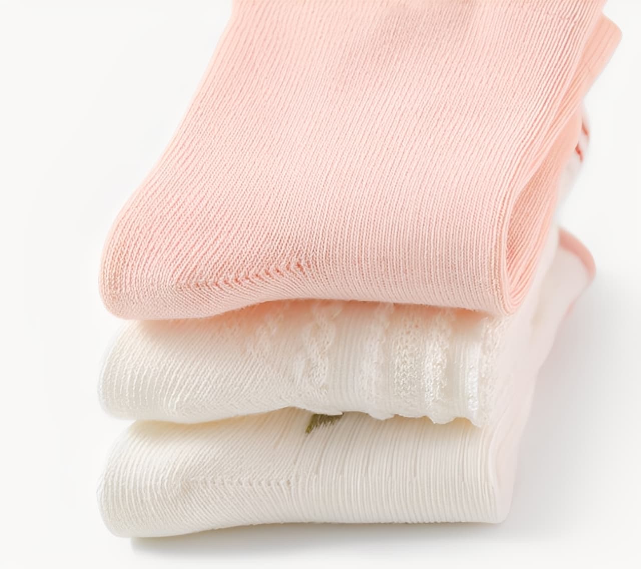 Folded stack of soft pink and white cotton baby socks