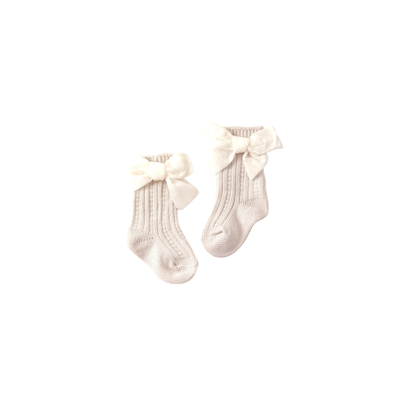 Cream baby socks with soft velvet bows — elegant ribbed cotton socks for baby girls.