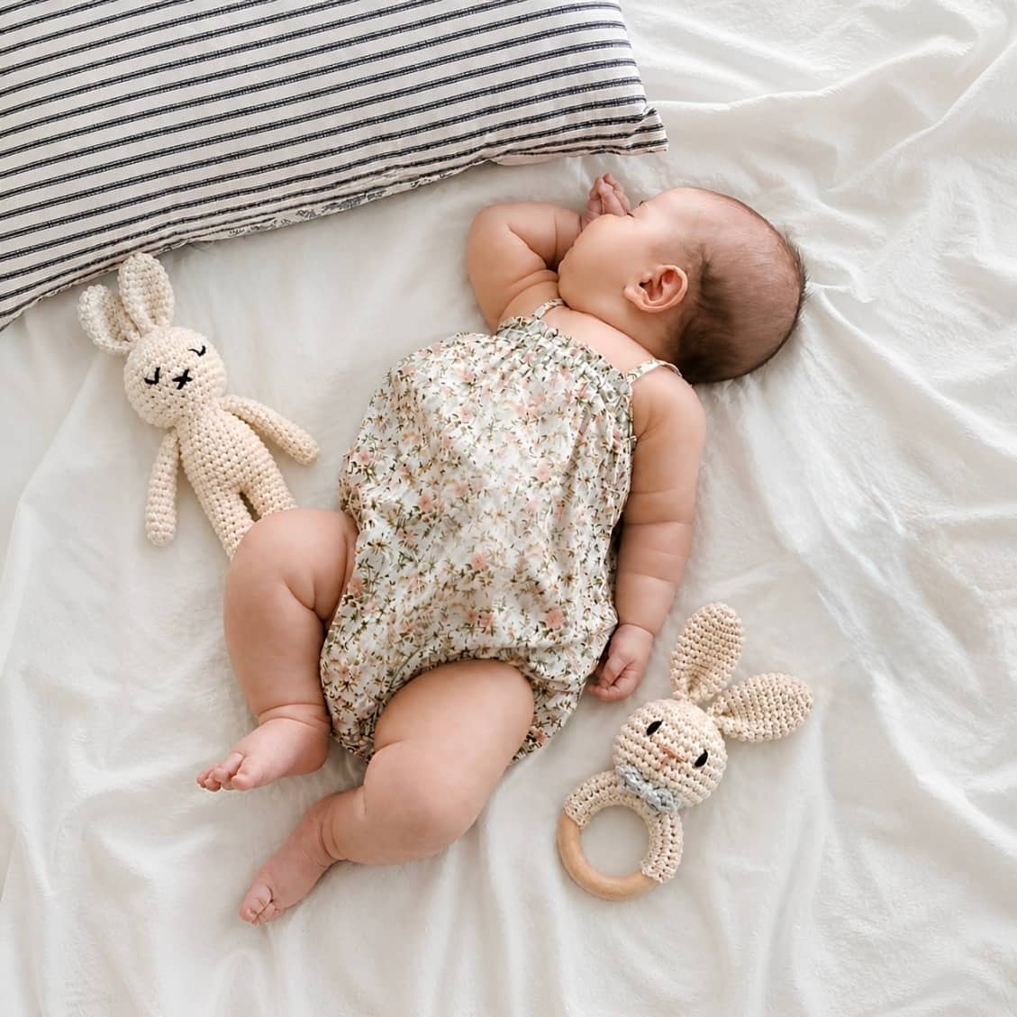 Newborn baby resting beside a crochet bunny comforter and bunny rattle set, a thoughtful baby shower gift and newborn essential in the UK.