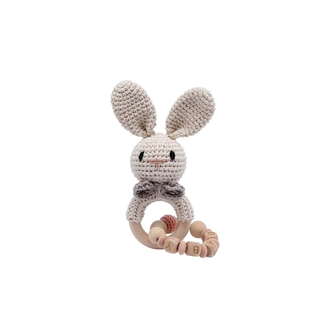 Handmade crochet rabbit rattle with chain and natural wooden ring, a sensory newborn baby toy perfect for baby shower gifts and nursery essentials.