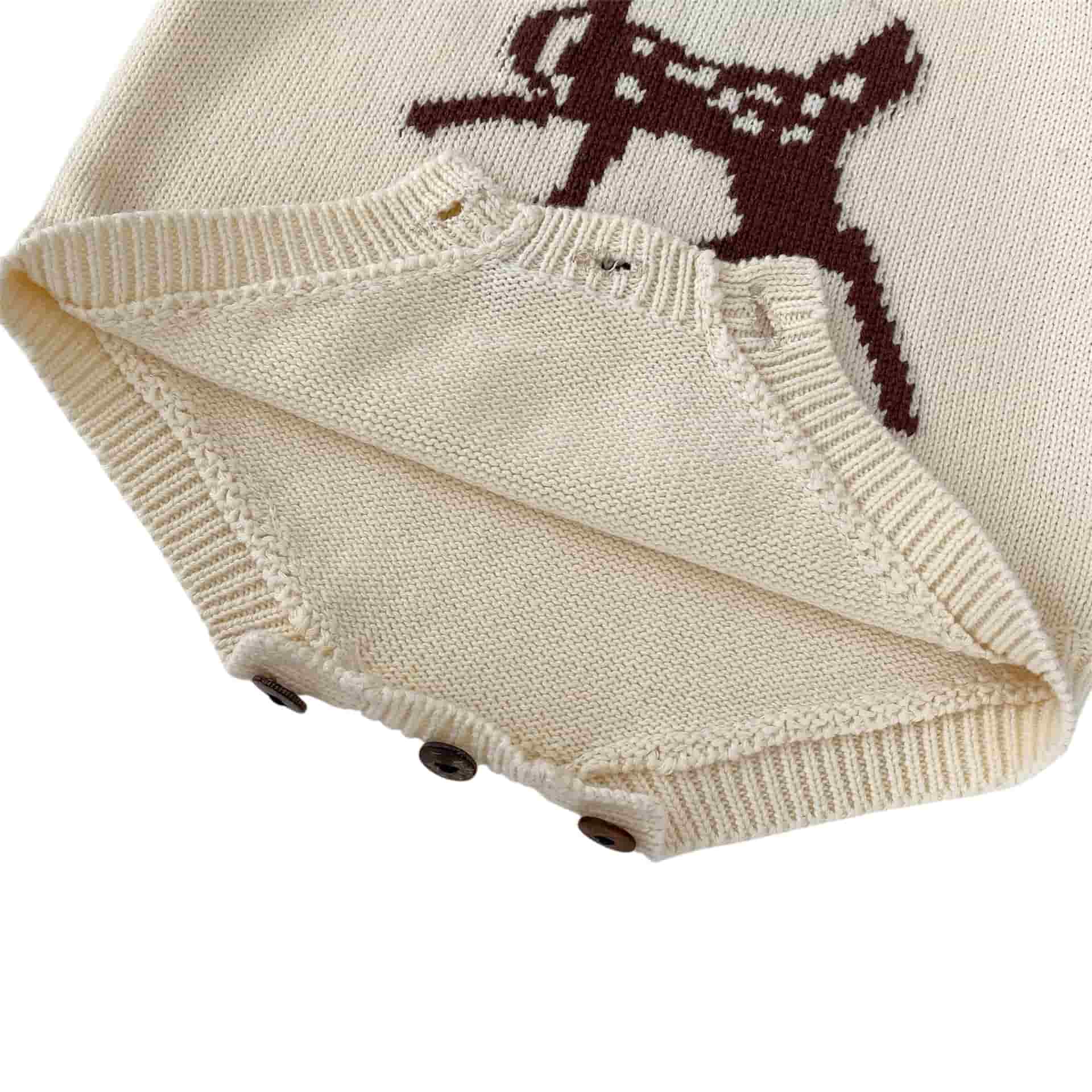 Close up of baby knit romper showing bottom button fastenings and soft knitted texture
