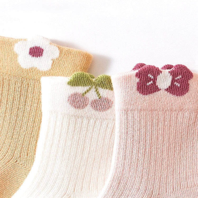 Flatlay of pastel floral cotton baby socks folded neatly – 3-pack