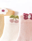 Flatlay of pastel floral cotton baby socks folded neatly – 3-pack