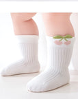 Baby wearing white floral baby socks – breathable cotton with embroidered flower