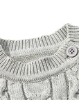 Detailed view of collar and button on gray cable knit baby romper, highlighting fine stitching and ribbed neckline.
