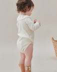 Side view of baby girl wearing soft cotton bow socks in pastel color.