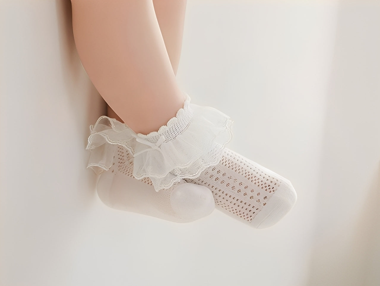 Baby feet wearing elegant lace cotton socks for newborns and toddlers