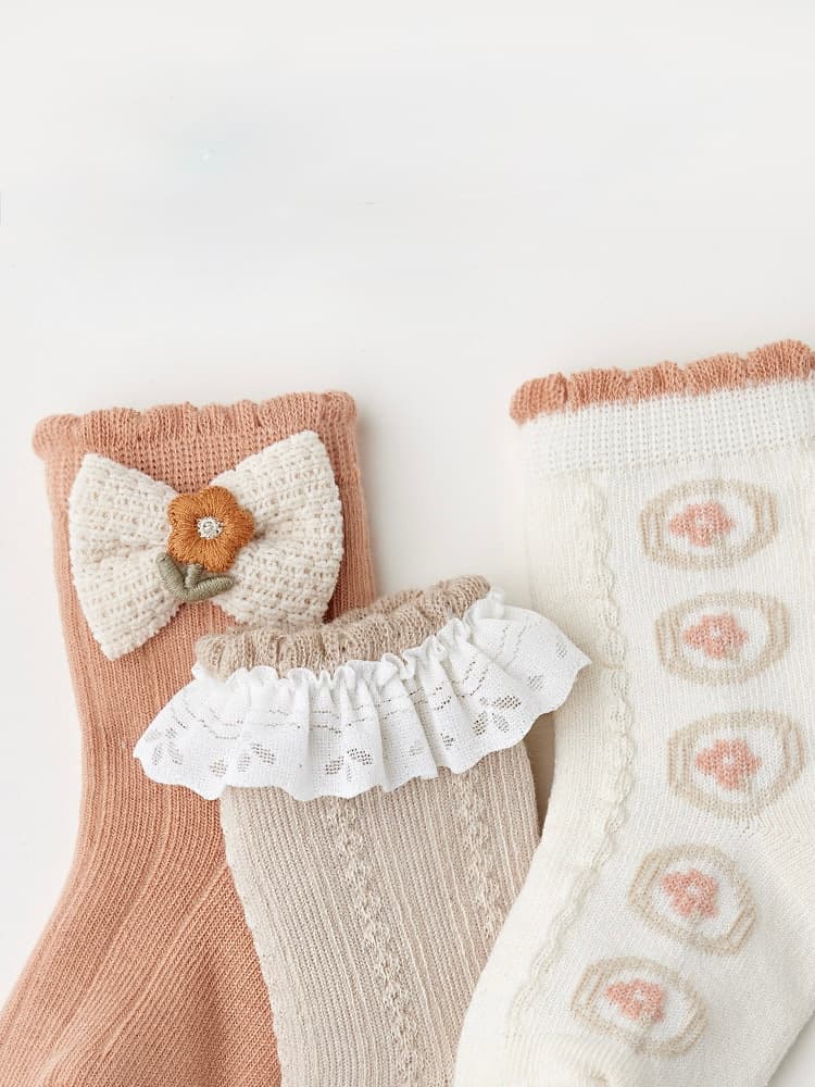 Neutral color baby socks set with lace and knit texture for stylish comfort.
