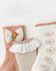 Neutral color baby socks set with lace and knit texture for stylish comfort.
