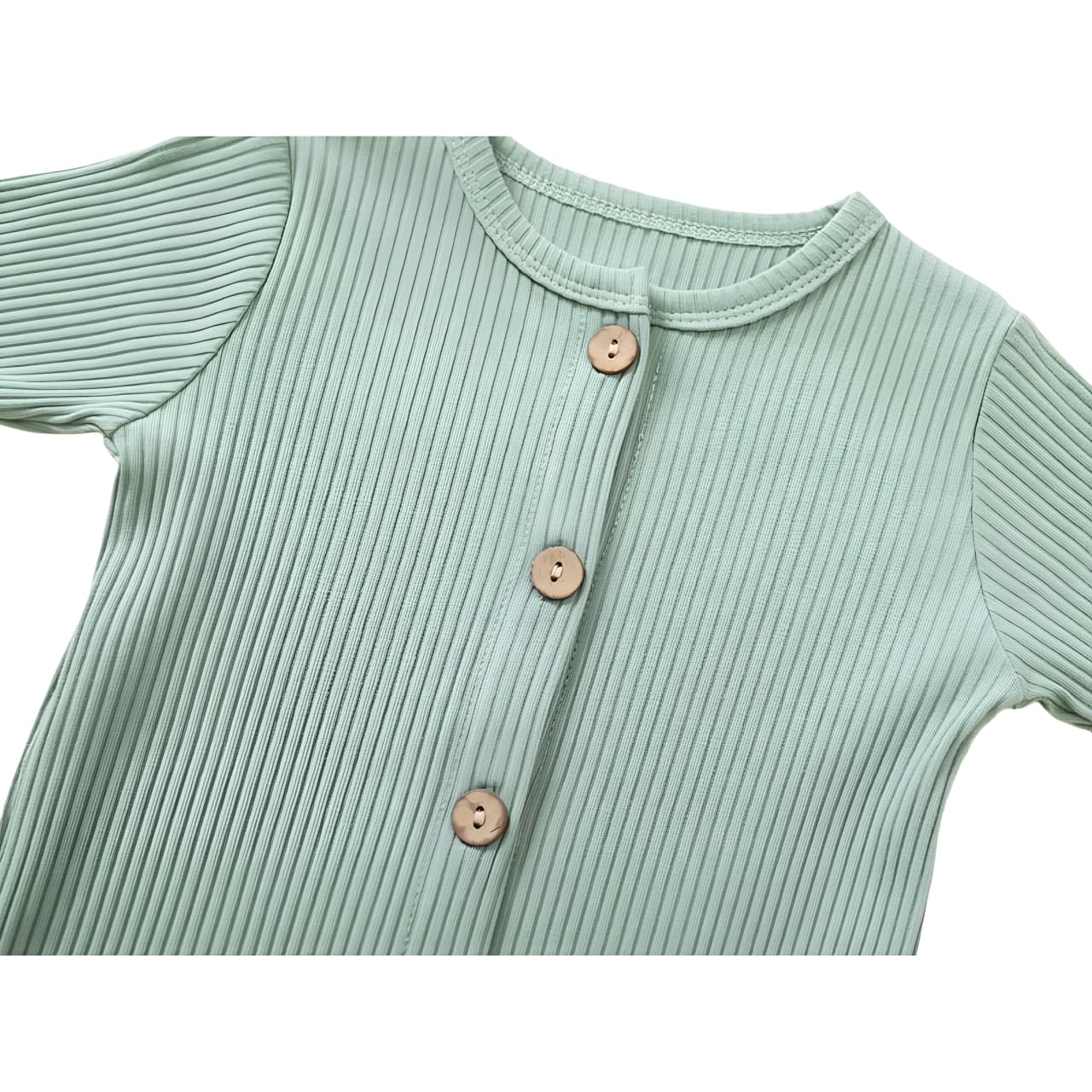 Close-up of wooden button detail on light green ribbed cotton baby jumpsuit.