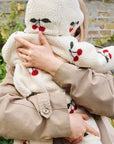 Mother holding baby wearing cherry-pattern fleece hooded jumpsuit for cozy outdoor warmth
